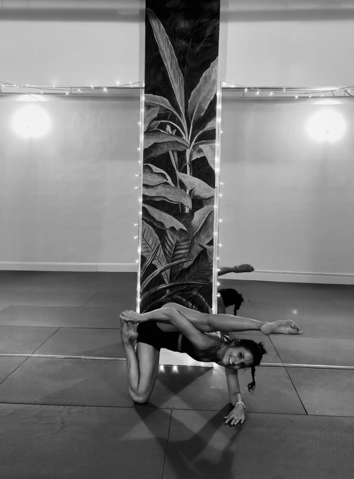 Hot yoga and Pilates flexibility pose by the palm mural column at Destin Hot Yoga